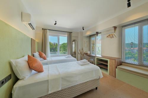 een grote slaapkamer met een groot wit bed en ramen bij Mediterranean Villa with Private Pool in Fethiye