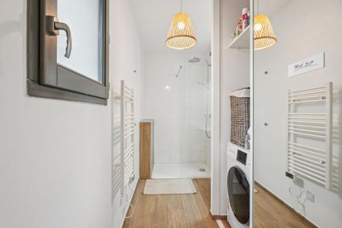 um banheiro com chuveiro e máquina de lavar em " Casa Nova " Cosy et calme en hypercentre em Lyon