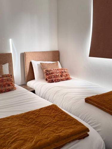 a room with two beds with pillows on them at The Rewind Retreat in Sandwich