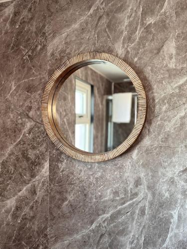 a mirror on a wall in a bathroom at The Rewind Retreat in Sandwich