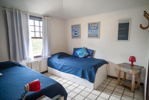 Casa em Buzios Proxima da Praia - BRD2 في بوزيوس: غرفة نوم بها سريرين ونافذة