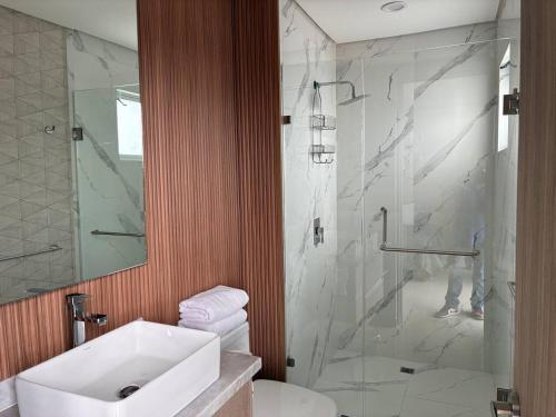 a bathroom with a sink and a glass shower at Alojamiento de Lujo a Pie de Playa By GPSRentas in Isla Venados