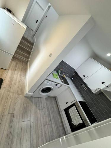 a kitchen with white cabinets and a sink and wood floors at Central London room w kitchen in London