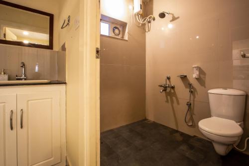 a bathroom with a toilet and a sink and a shower at Lakefront 1 BR Cabin with Lake access & Hammock in Kollam