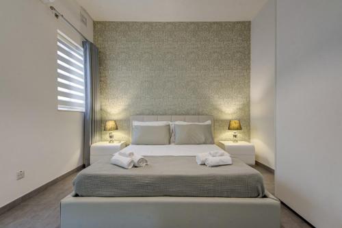 a bedroom with a large bed with two towels on it at Forum Swieqi, Luxury Apartment, 2BD-2BH, Sleeps 4 in Is-Swieqi