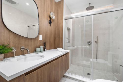 a bathroom with a sink and a shower with a mirror at Pond House at Carter Bridge Estate in Freehold