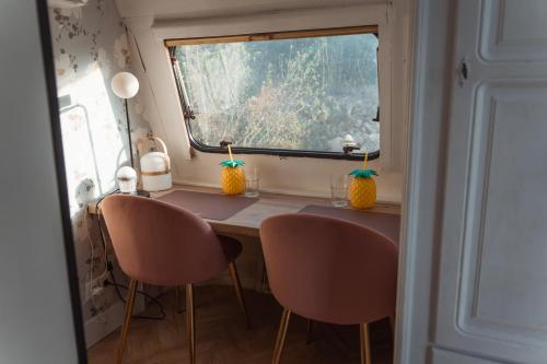 einen Tisch und Stühle in einem winzigen Haus mit Fenster in der Unterkunft Suite Caravan by Noches de Calig in San Jorge