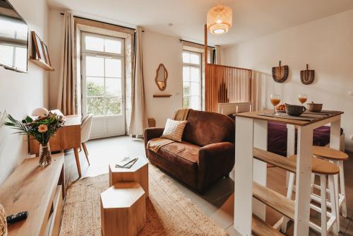een woonkamer met een bank en een tafel bij Le Cocon Carmel by CozyLife in Niort