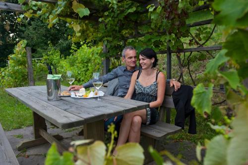 a man and a woman sitting at a picnic table at Familienhotel Post in Millstatt