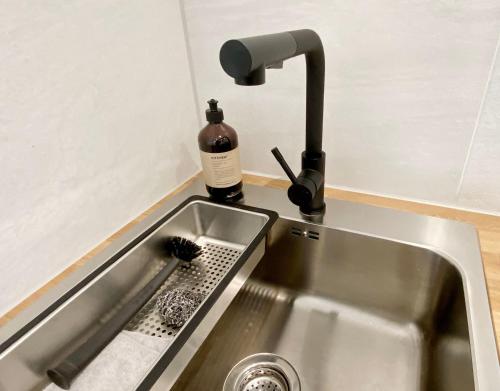 een wastafel met een fles zeep en een borstel bij Apartment ANi, E-Parkplatz Göppingen 2Zi, 60qm zentrale Wohnung, Zweifamilienhaus, Terrasse, Garten, ruhig, direkt an Fahrradstraße, nahe EWS Arena in Göppingen