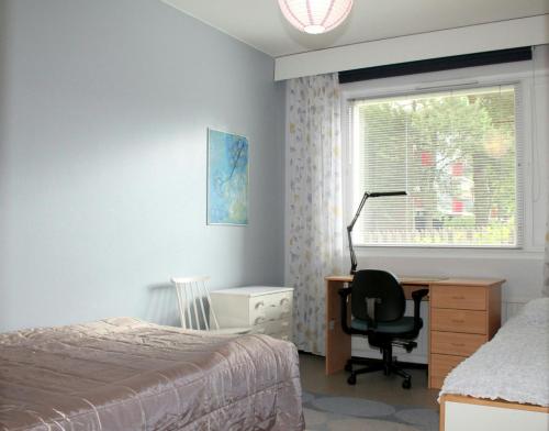 une chambre avec un lit, un bureau et une fenêtre dans l'établissement Convenient Apartment for 3 in Varissuo, à Littoinen