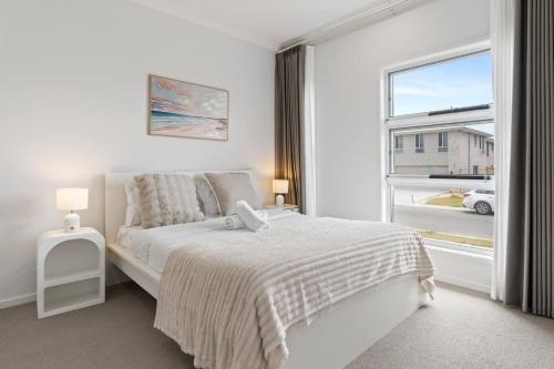 a white bedroom with a bed and a window at Modern House with Patio and Family Comfort) in Park Ridge