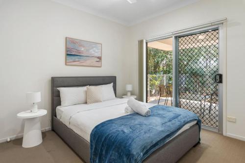 a bedroom with a bed with a blue blanket on it at Charming 2BR Home in Serene Mount Warren Park in Windaroo