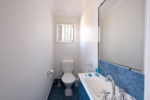 Coastal 2BR Retreat Heart of Broadbeach Living في غولد كوست: حمام مزود بمرحاض ومغسلة ومرآة