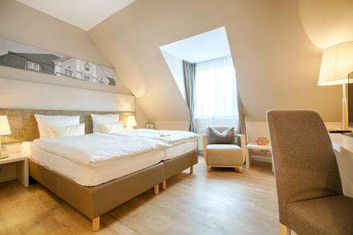 a hotel room with a bed and a chair at Best Western Plus Theodor Storm Hotel in Husum