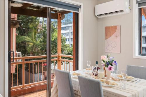 Modern 2BR Apartment Beach and Dining in Broadbeach في غولد كوست: غرفة طعام مع طاولة وشرفة