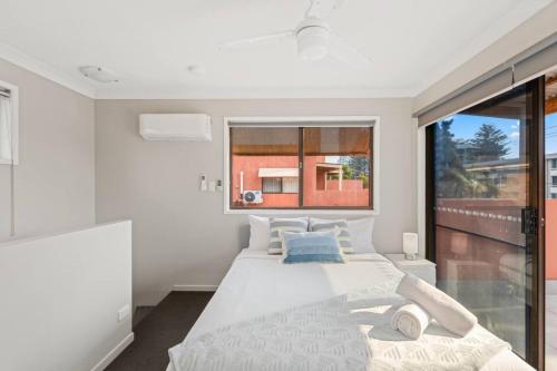 Modern 2BR Apartment Beach and Dining in Broadbeach في غولد كوست: غرفة نوم بيضاء مع سرير كبير ونافذة
