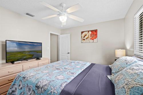 a bedroom with a bed and a flat screen tv at Florida Flair Villa in Cape Coral Hospital Heliport