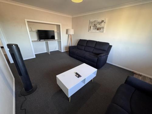 a living room with a couch and a tv at Apartments on Turf Unit 4 in Grafton