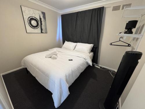 グラフトンにあるApartments on Turf Unit 4の白いシーツが敷かれた大きなベッドのある寝室