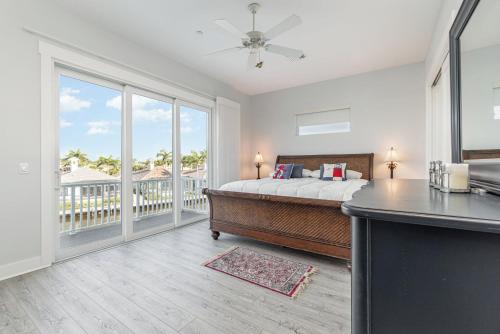 a bedroom with a bed and a balcony at Funky Fish House Villa in Shell Point Village