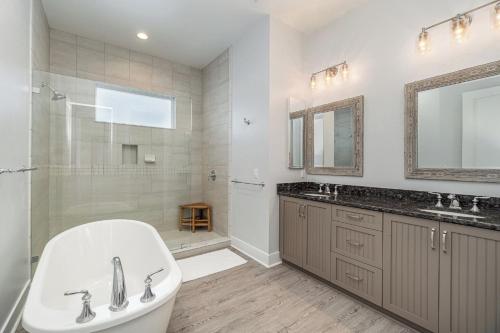 a bathroom with a tub and a sink and a shower at Funky Fish House Villa in Shell Point Village