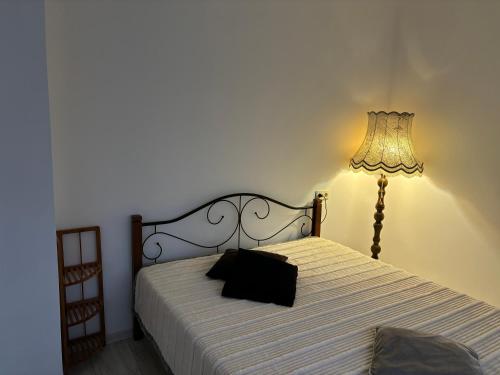 a bedroom with a bed with a lamp next to it at Vecpilsētas apartaments in Cēsis