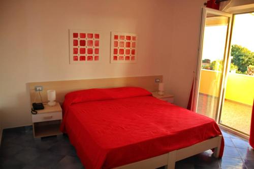 a bedroom with a red bed and a window at Belvedere in Procida
