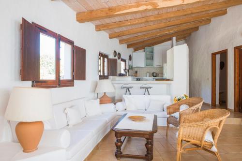 Una sala de estar con un sofá blanco y una mesa. en Finca Fiori 2, en Is Molas 