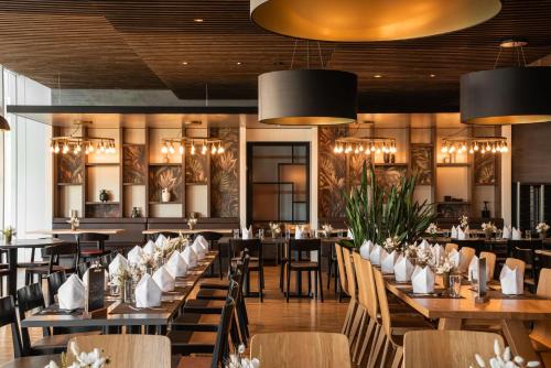 Un comedor con mesas, sillas y candelabros. en Hotel Sempachersee, en Nottwil