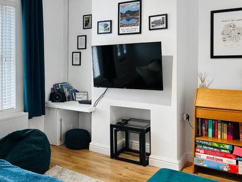 a living room with a flat screen tv on a wall at Miner's Rest in Rowrah