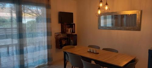 a dining room with a table and chairs and a mirror at Maison au pin in Narbonne-Plage