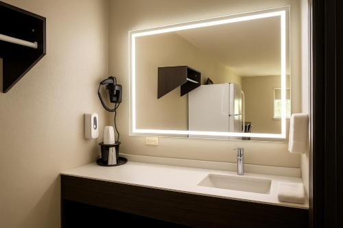 a bathroom with a sink and a large mirror at Paragon Inn Hillsboro in Hillsboro