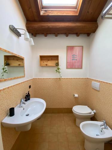 a bathroom with two sinks and a toilet at Locanda Merlaschio in Faenza