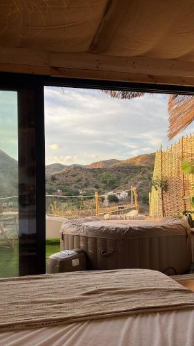 a room with a window with a view of a mountain at Glamping Cabaña Suite Los Almendros in Málaga