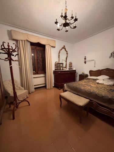 a bedroom with a bed and a chair and a chandelier at Sa Torre in Campos