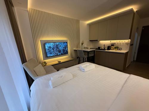 a hotel room with a white bed and a kitchen at Alpina Lux in Kopaonik