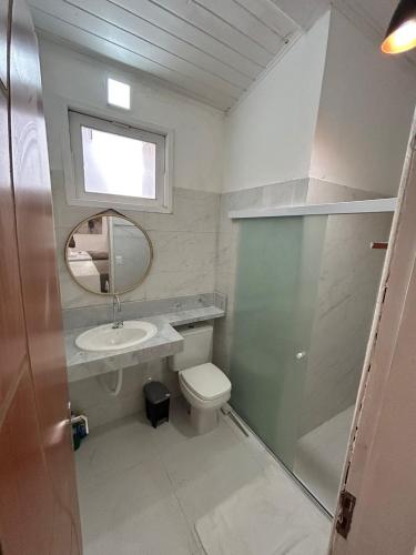 une salle de bains avec toilettes, lavabo et miroir dans l'établissement Gute Morro Villa Apartments, à Cairu