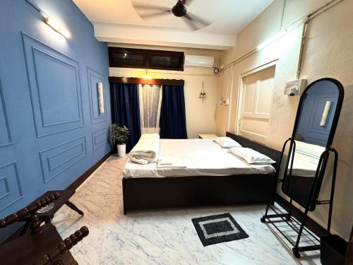 a bedroom with a bed and a blue door at Varnas Cosy Stay in Guwahati