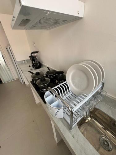 a kitchen with a stove with plates and pans at Flat Gute Morro - Praça Central in Cairu