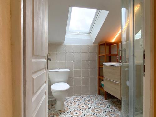 a bathroom with a toilet and a window at Gîte Les Ebeteux in Fraize