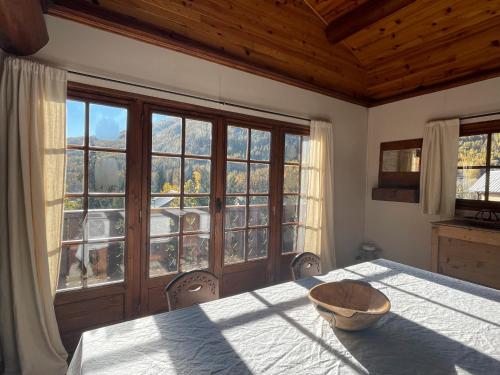 a dining room with a table and a large window at South-facing Chalet With Views in Le Villard-Late
