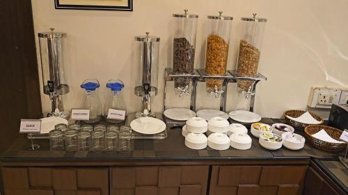 un mostrador con tazones y recipientes de comida. en Hotel Tirupati Plaza, en Kota