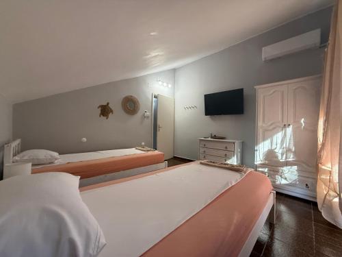 a bedroom with two beds and a tv on the wall at Вила Мечта in Starozagorski Bani
