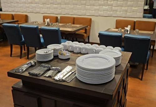 una mesa con platos y utensilios encima en Hotel Tirupati Plaza, en Kota