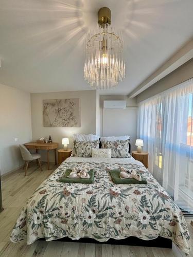 a bedroom with a large bed with a chandelier at HelloWine Apartman in Eger
