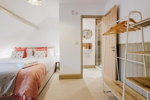 ein Schlafzimmer mit einem Bett und einem begehbaren Kleiderschrank in der Unterkunft Wisteria Cottage 3 Bed Garden & Free Parking in Kenilworth