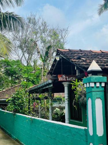 a restaurant with a sign on the side of a building at Villa Turtle in Galle