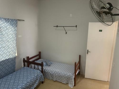 a bedroom with two beds and a fan at Hotel Automatiza no Centro da Cidade in Uberaba