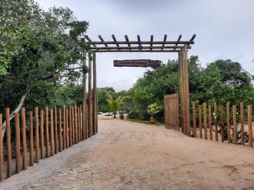 a gate with a sign over a dirt road at Passos da Lagoa in Itapemirim